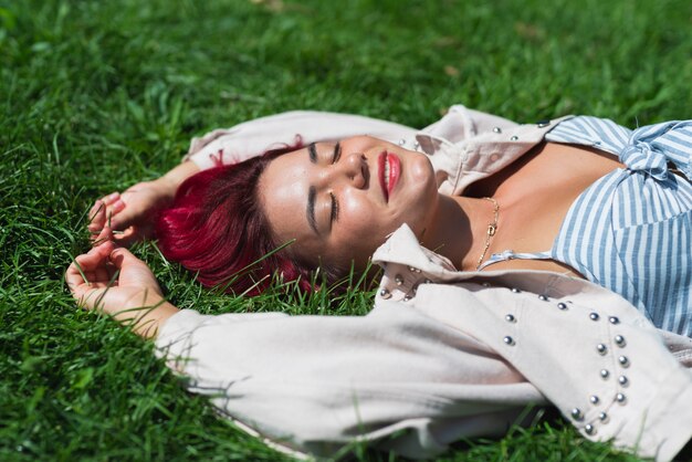 Mulher, com, cabelo vermelho, mentir grama