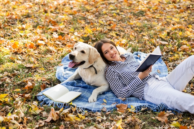 Foto grátis mulher com cachorro fofo sentado em um cobertor