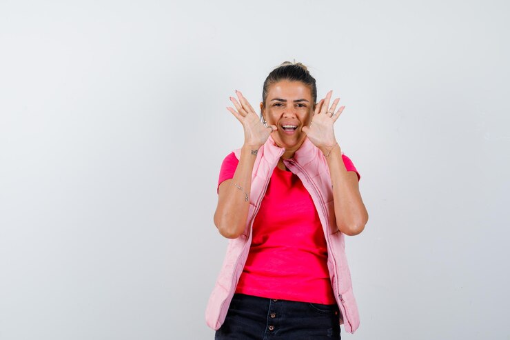 Foto grátis mulher com camiseta, colete mostrando as palmas das mãos e parecendo feliz