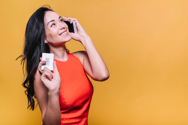 Mulher, com, cartão crédito, falando, por, telefone