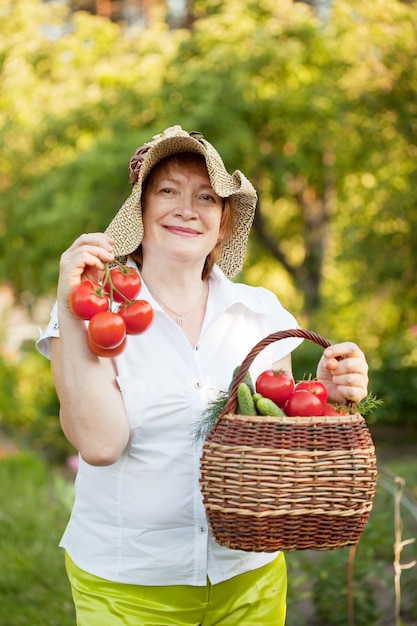 Mulher com cesta de vegetais colhidos