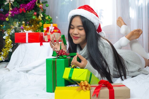 Mulher com chapéu de natal feliz com presente de natal