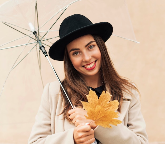 Mulher com chapéu preto segurando um guarda-chuva