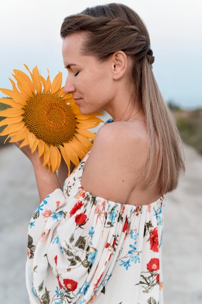 Foto grátis mulher com cheiro de girassol