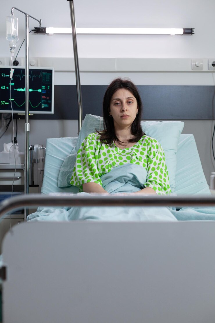 Foto grátis mulher com doença sentada na cama de hospital recebendo tratamento intravenoso da linha de gotejamento iv conectada ao monitor de medição dos sinais vitais. paciente doente tratado com soro fisiológico para hidratação.