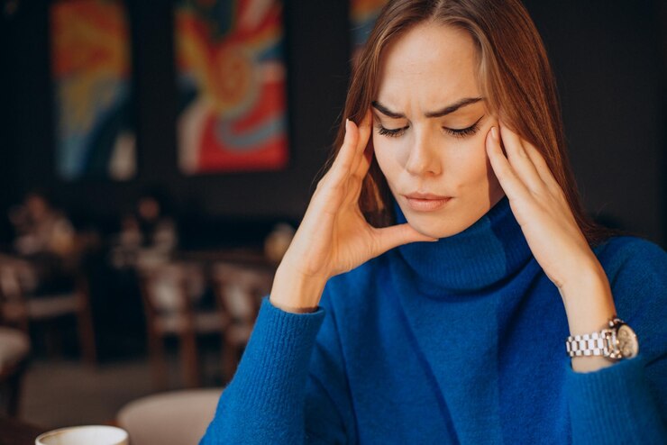 Foto grátis mulher com dor de cabeça enquanto trabalha em um café
