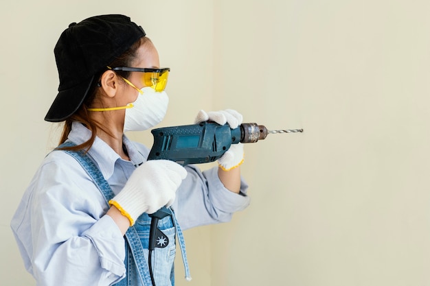 Foto grátis mulher com equipamento de proteção de segurança trabalhando