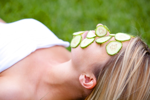 Foto grátis mulher com fatias de pepino sobre o rosto