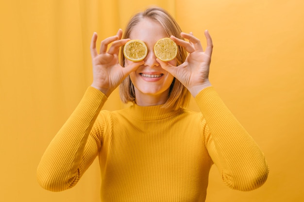 Mulher, com, fatias limão, frente, olhos, em, um, amarela, cena