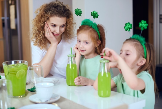 Mulher com filhos comemorando o dia de são patrício em casa