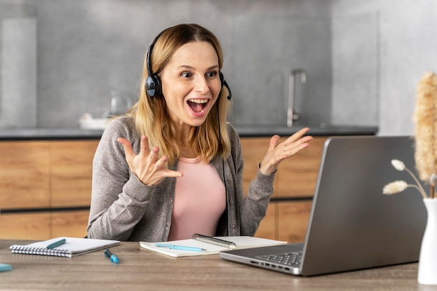 Mulher com fone de ouvido trabalhando no laptop