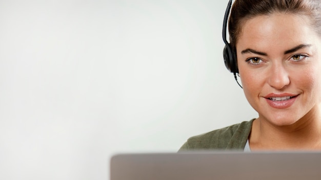 Mulher com fone de ouvido usando laptop