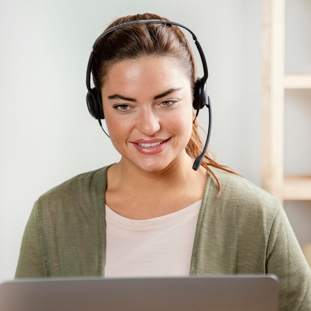 Foto grátis mulher com fone de ouvido usando laptop