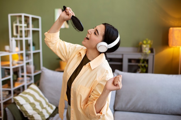 Foto grátis mulher com fones de ouvido e escova, cantando