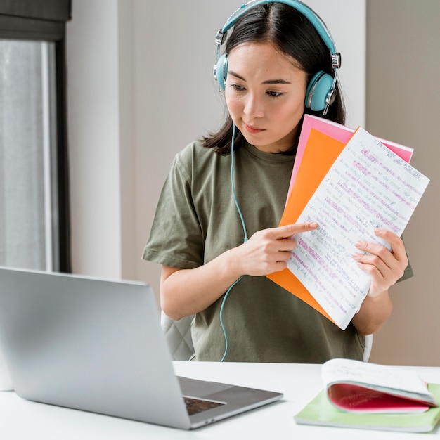 Mulher com fones de ouvido fazendo videochamada no laptop