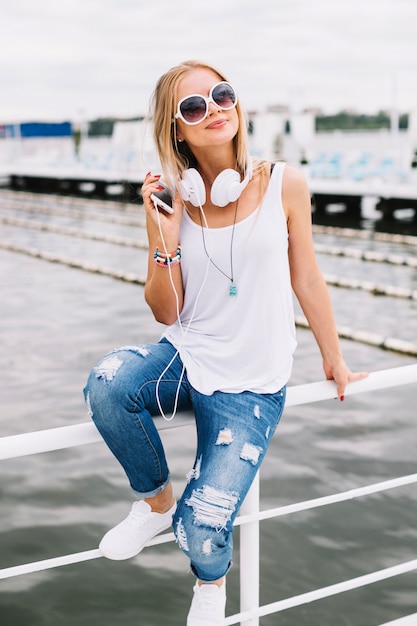 Foto grátis mulher com fones de ouvido na cerca