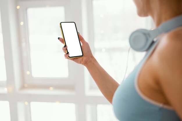 Mulher com fones de ouvido usando telefone