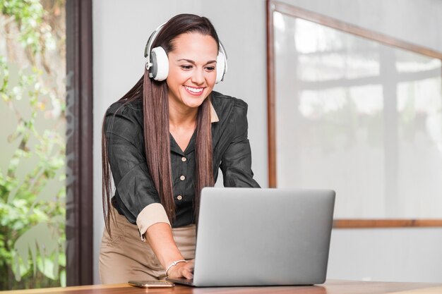 Mulher, com, fones, verificar, dela, laptop