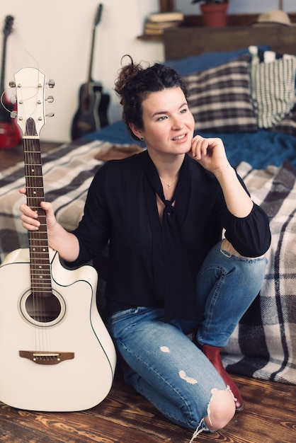 Foto grátis mulher com guitarra pensando