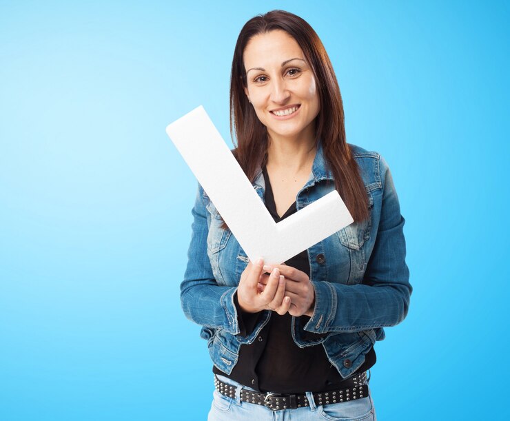 Foto grátis mulher com jaqueta jeans, sorrindo com a letra &quot;l&quot;