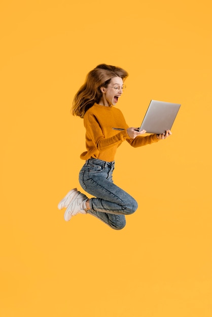 Mulher com laptop pulando