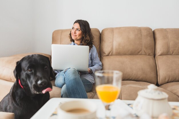 Mulher com laptop sentado no sofá