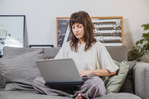 Foto grátis mulher com laptop sentado no sofá