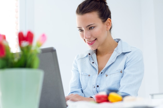 Mulher com laptop trabalhando em casa