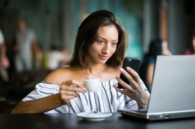 Mulher com laptop trabalhando em um café