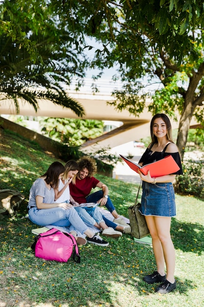 Mulher, com, livro aberto, parque, com, amigos