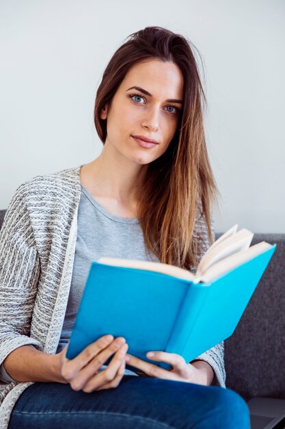 Mulher com livro no sofá