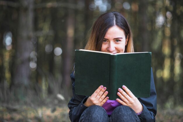 Mulher, com, livro, olhando câmera