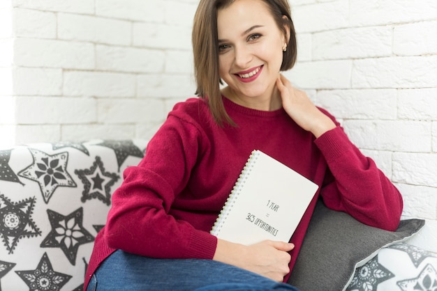 Foto grátis mulher com livro que olha a camara