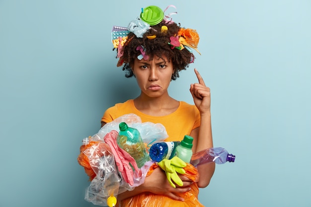Mulher com lixo plástico em saco de rede