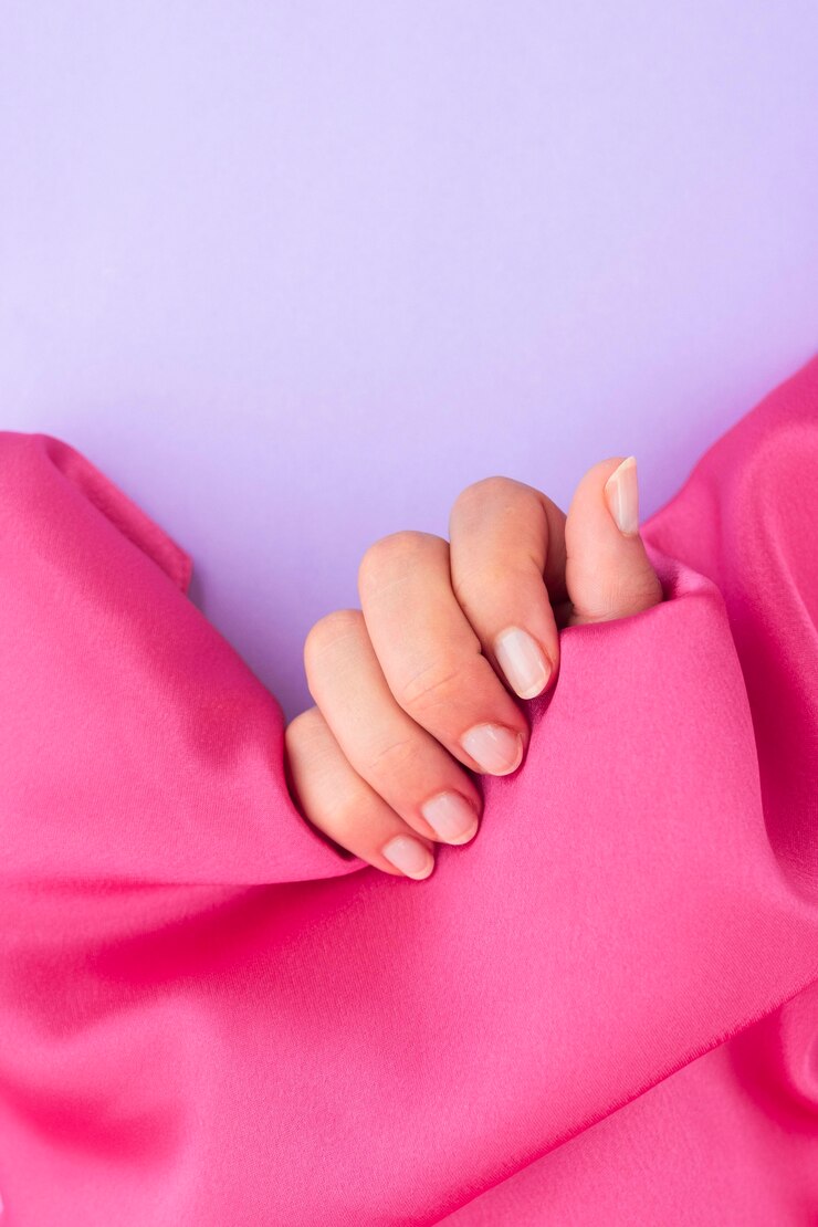 Foto grátis mulher com manicure pronta segurando um pano rosa com espaço de cópia