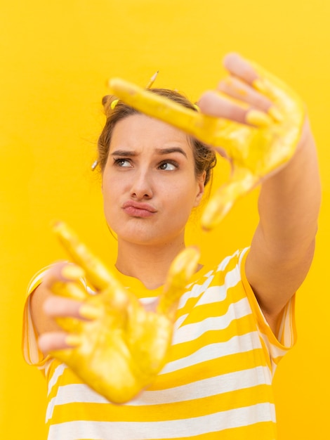 Foto grátis mulher com mãos pintadas amarelas