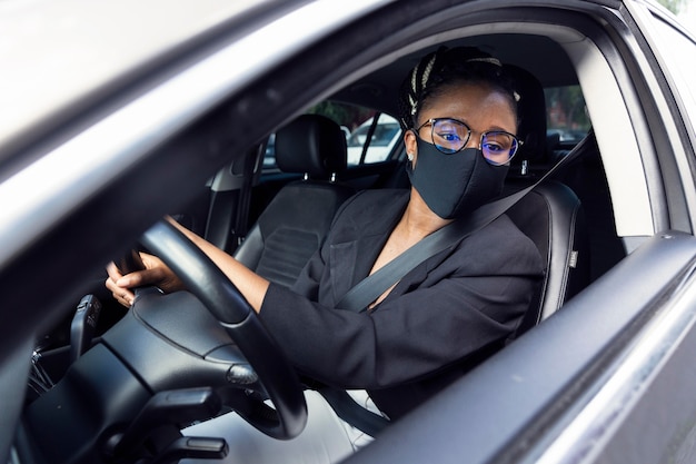 Foto grátis mulher com máscara facial olhando no espelho traseiro para dar ré no carro