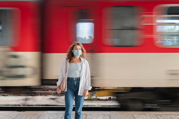 Mulher com máscara médica na estação de trem pública