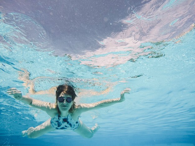 Mulher com óculos de mergulho na piscina