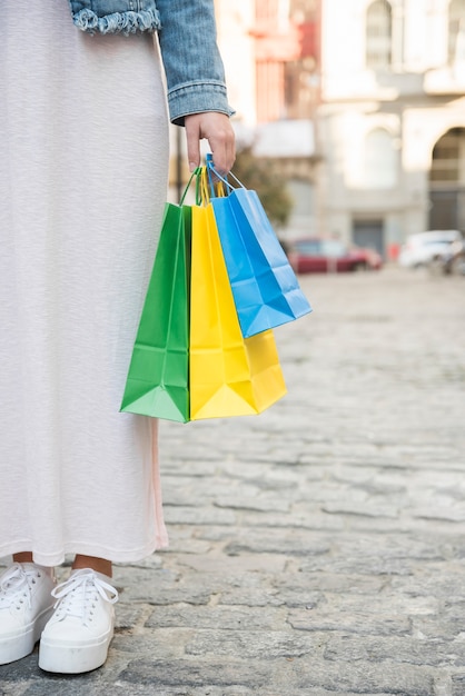 Foto grátis mulher com pacotes de compras brilhantes na rua