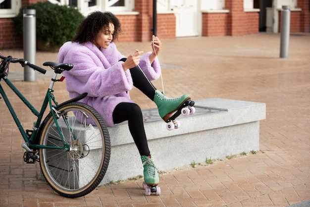 Foto grátis mulher com patins amarrando seus cadarços ao ar livre