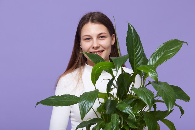 Mulher com planta verde flor nas mãos