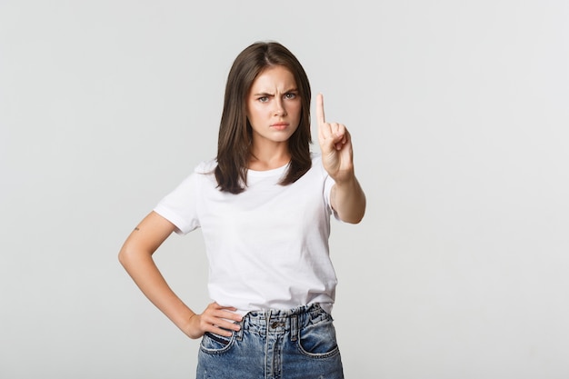 Mulher com raiva e decepcionada balançando o dedo em desaprovação, repreendendo a pessoa que toma a decisão errada.