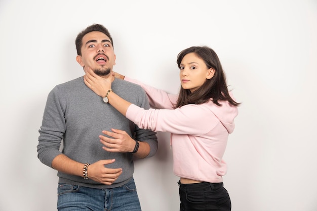 Mulher com raiva, estrangulando o namorado de brincadeira.