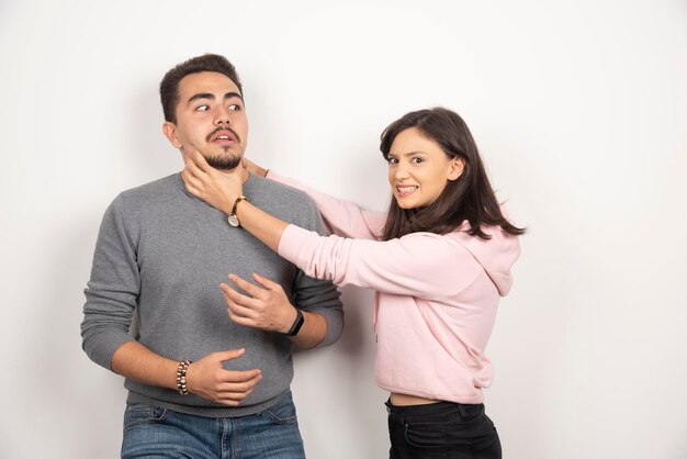 Mulher com raiva, estrangulando o namorado de brincadeira.