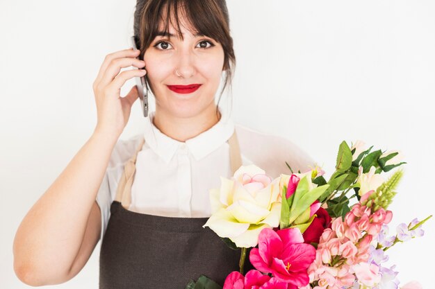 Mulher com ramo de flores falando no celular