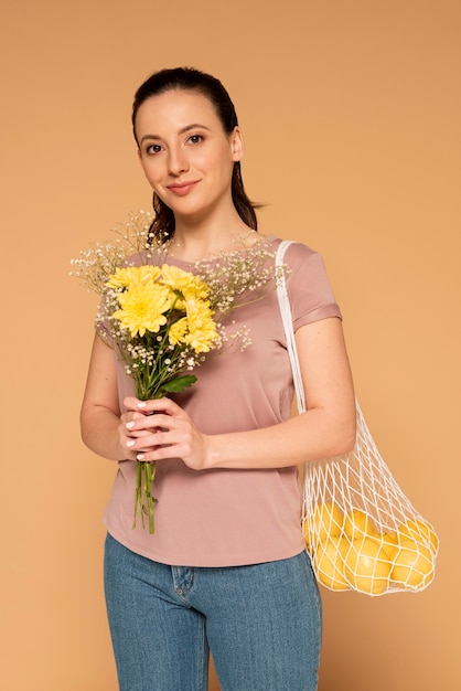 Mulher com roupas casuais carregando uma bolsa reutilizável de tartaruga e flores