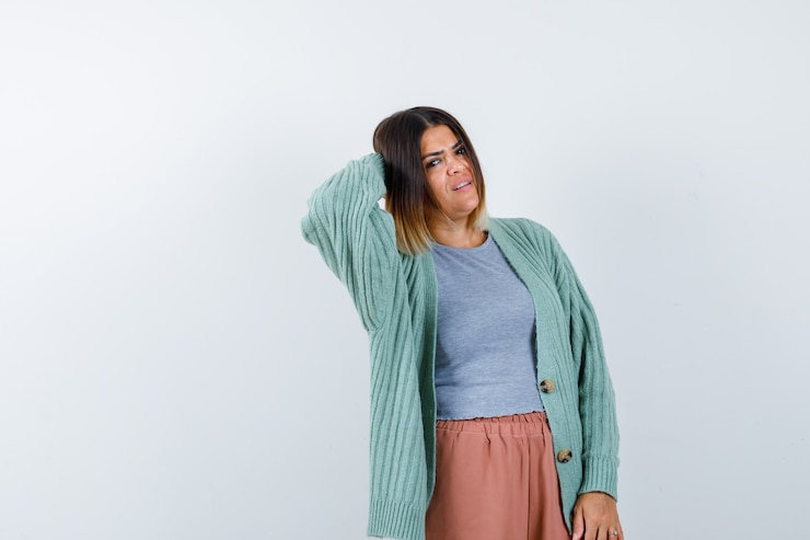 Foto grátis mulher com roupas casuais, mantendo a mão atrás da cabeça e parecendo confusa, vista frontal.