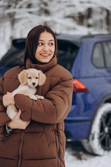 Mulher com seu cachorro fofo perto do carro