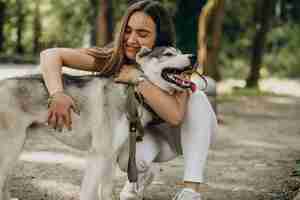 Foto grátis mulher com seu cachorro husky no parque